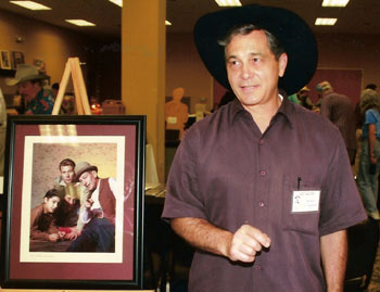 Bobby Crawford stands next to a cast shot of himself, John Smith and Hoagy Carmichael on “Laramie”.