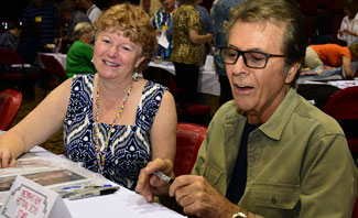 Festival registration desk volunteer Fliss Bonello lends a helping hand to James Darren. 