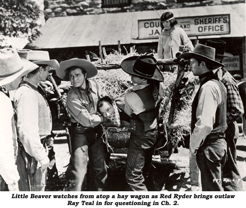 Little Beaver watches from atop a hay wagon as Red Ryder brings outlaw Ray Teal in for questioning in Ch. 2.