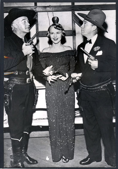 William Boyd as Hopalong Cassidy and crooner Bing Crosby engage in a friendly dispute over who wins singer Peggy Lee. At the time this photo was taken, circa 1951, Hoppy, Crosby and Lee were tenatively scheduled to made a musical western to be titled "Pardners".