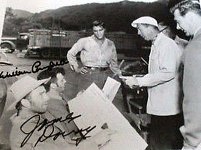 On the set of “Love Me Tender” Elvis Presley watches as director Robert Webb gives
some script notations to James Drury and William Campbell. 