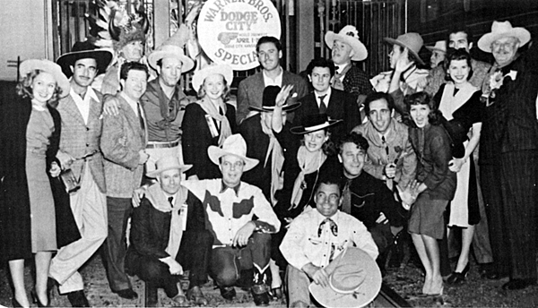 The Warner Bros. "Dodge City" promotional junket. (L-R standing) Rosemary Lane, Gilbert Roland, Frank McHugh, unidentified Indian, Maxie Rosenbloom, Pricilla Lane, Errol Flynn, unidentified below Flynn, John Garfield, unidentified, Wayne Morris, unidentified, John Payne, unidentified, Alan Hale. (L-R front row)unidentified, Hoot Gibson, Ann Sheridan, Buck Jones, Big Boy Williams, Humphrey Bogart, Jean Parker. 