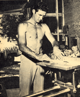 Six foot four, 200 pound Jock Mahoney in his garage workshop. 