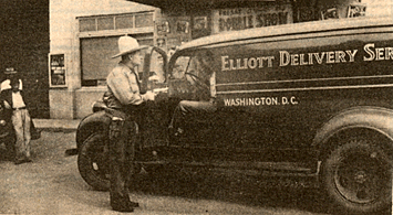 Clowning around, Max Terhune says, "Hold it right there, this is a hold-up", as he poses in front of the Stone theatre in Washington, D.C. during his personal appearance days.