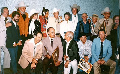 (L-R standing) Steve Brodie, 1985 festival organizer Mike Marx, Jock Mahoney, Penny Edwards, Iron Eyes Cody, Oliver Drake, Peggy Stewart, Sunset Carson, Vic Pettibone, Joe Iverson, Fred Scott, Lois January. (kneeling) Lucky Brown, Henry Wills, Terry Frost, Frank Mitchell, Neil Summers. 