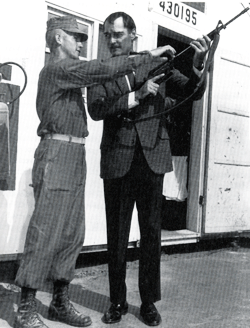 Soon assigned to the U.S. Marine Corps, a young Marine shows John Russell some of the latest weaponry. 