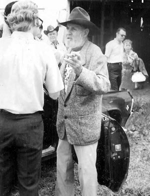 Ken Maynard talks with a newspaper reporter during a lull in the filming of “Marshal of Windy Hollow”. Jessie Baker looks on in the background.