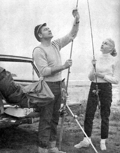 John Bromfield, star of “Sheriff of Cochise” and “U.S. Marshal”, and wife Larri Thomas get ready for a bit of surf fishing off the coast of California. 