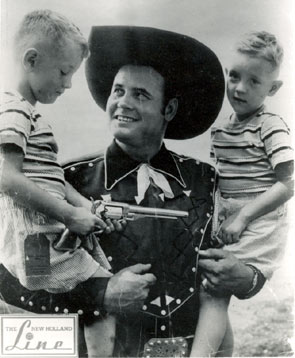 Sunset Carson lets two admiring fans examine his six-gun. The photo bares a “The New Holland Line” logo. Not sure, but we do know, thanks to Bill Thomas, that Sunset’s brother Dale Harrison owned a farm equipment company in Texas. Being as how New Holland is a large farm equipment company, we’re betting did some promotional work for New Holland. Matter of fact, the boys may even be Sunset’s nephews. Photo probably originates in the ‘50s after Sunset’s movie career ended.