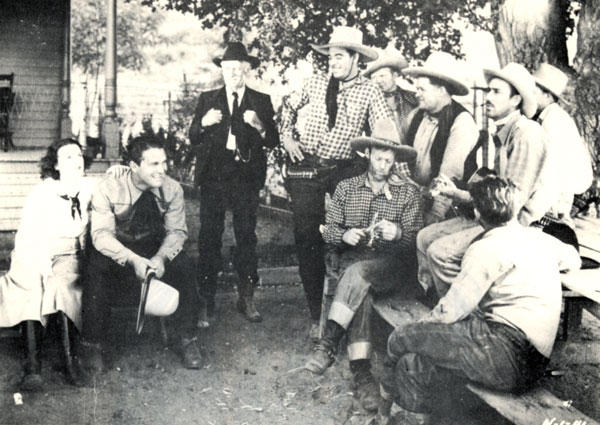 Taking a break from making “Law of .45s” (‘35 First Division) are (l-r) Molly O’Day, Big Boy Williams, Lafe McKee, Glenn Strange, Jack Evans, Jack Kirk, Sherry Tansey, unknown behind Tansey, Al St. John seated, unknown.