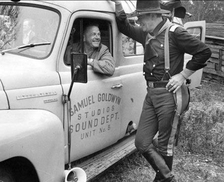 John Wayne talks with (possibly sound man Jack Solomon) during a break on “The Horse Soldiers”.