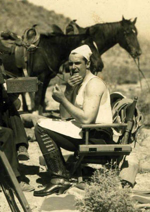 On the range, Ken Maynard applies make-up from his own tooled leather make-up kit of which WESTERN CLIPPINGS is now the proud owner. (Photo courtesy Jerry Whittington.)