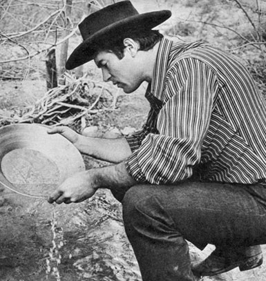 Clint pans for precious gold ore, washing the sand carefully to remove excess mud and rocks from the silt.