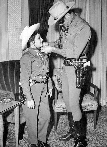 Clayton Moore ties the scarf of a young Boston fan. Clayton was in Boston to promote “The Lone Ranger” 1956 film.