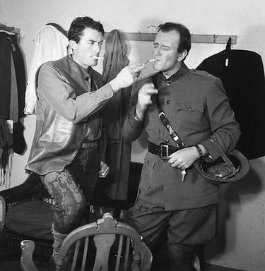 Gregory Peck visits John Wayne on the set of “Blood Alley” (‘55 WB).